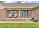 Cozy covered porch with brickwork, seating, and a welcoming teal front door at 1934 Constitution St, Greenfield, IN 46140