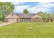 Charming brick home featuring a well-manicured lawn and a delightful covered front porch at 1934 Constitution St, Greenfield, IN 46140