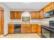 Bright kitchen with wood cabinets, laminate countertops, stainless steel sink, and black appliances at 1934 Constitution St, Greenfield, IN 46140