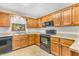 Traditional kitchen featuring wood cabinets, linoleum countertops, and black appliances at 1934 Constitution St, Greenfield, IN 46140