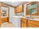 Functional laundry room with washer, dryer, utility sink, and cabinets, next to an open bathroom at 1934 Constitution St, Greenfield, IN 46140
