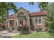 Charming brick home with red tile roof, vibrant front yard, and inviting red front door at 196 E Madison St, Franklin, IN 46131
