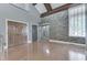 An open living space with hardwood floors, a stone accent wall, and two large windows at 196 E Madison St, Franklin, IN 46131