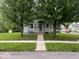 Charming home exterior with well-maintained lawn and gray siding and mature trees in a residential neighborhood at 209 N Lincoln St, Martinsville, IN 46151