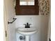 Charming powder room with stylish sink, black hardware, and nature-inspired wallpaper at 223 E Fordice St, Lebanon, IN 46052