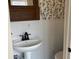 Charming powder room with pedestal sink, stylish mirror, and decorative wallpaper at 223 E Fordice St, Lebanon, IN 46052