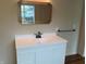Bathroom vanity featuring white cabinetry, a modern faucet, and a decorative mirror at 223 E Fordice St, Lebanon, IN 46052