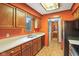 Eat-in kitchen featuring wood cabinets, white countertops, and a view into the adjacent laundry and washroom at 2430 Spring Hill Ct, Indianapolis, IN 46268