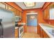 Eat-in kitchen featuring stainless steel appliances, wood cabinets, and a view into the adjacent dining area at 2430 Spring Hill Ct, Indianapolis, IN 46268