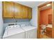 Bright laundry room with upper cabinets and adjacent powder room at 2430 Spring Hill Ct, Indianapolis, IN 46268