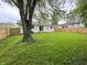 Large grassy backyard is fully fenced and surrounded by mature trees providing privacy at 2431 Timbercrest Dr, Columbus, IN 47203