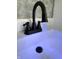 Bathroom sink featuring a black faucet with blue lighting and stone countertop at 2431 Timbercrest Dr, Columbus, IN 47203