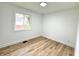 Bright bedroom featuring wood floors, white walls, and a window overlooking a yard at 2431 Timbercrest Dr, Columbus, IN 47203