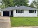Charming white brick home with black shutters, complemented by a well-maintained lawn and black garage door at 2431 Timbercrest Dr, Columbus, IN 47203