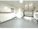 Spacious garage with overhead lighting and convenient storage shelves is perfect for your cars at 2431 Timbercrest Dr, Columbus, IN 47203