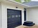 Attached one-car garage with a black garage door and steps up to the front door at 2431 Timbercrest Dr, Columbus, IN 47203