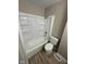 Bathroom featuring a shower-tub combo with tile surround, along with laminate flooring at 2453 Larnie Ln, Indianapolis, IN 46219