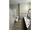 Bathroom featuring a shower-tub combo, double sinks, a large mirror, and laminate flooring at 2453 Larnie Ln, Indianapolis, IN 46219