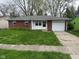 A well-kept single-story home shows off its brick facade, shutters, and attached one car garage at 2453 Larnie Ln, Indianapolis, IN 46219