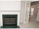 Close up of Fireplace with green tile surround with open glass paneled door to another room at 2708 N Buck Creek Rd, Greenfield, IN 46140