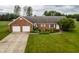 Charming brick home featuring an attached two-car garage and lush lawn at 2708 N Buck Creek Rd, Greenfield, IN 46140