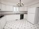 Bright kitchen featuring white cabinetry, black appliances, and black and white checkered flooring at 2708 N Buck Creek Rd, Greenfield, IN 46140