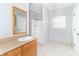 Bathroom with a white shower stall, window, wood vanity, and beige floor tiles at 2761 Winding Creek Ln, Greenfield, IN 46140