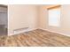 A sunlit bedroom with wood-look flooring, a window with blinds, and neutral walls at 2761 Winding Creek Ln, Greenfield, IN 46140