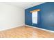 Sunny bedroom with laminate flooring and a contemporary blue accent wall at 2761 Winding Creek Ln, Greenfield, IN 46140