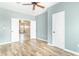 Bright bedroom featuring wood-look floors and a view to the living room through open doors at 2761 Winding Creek Ln, Greenfield, IN 46140