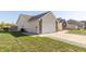 The side of the home showing a two-car garage, an air conditioning unit, and a well-kept lawn at 2761 Winding Creek Ln, Greenfield, IN 46140