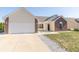 Well-maintained home featuring a two-car garage, a brick facade, and manicured landscaping at 2761 Winding Creek Ln, Greenfield, IN 46140