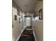 Long hallway with picture frames hanging on the wall with a white door at the end at 2761 Winding Creek Ln, Greenfield, IN 46140