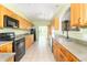 Well-lit kitchen featuring wood cabinets, a sink, and modern appliances on tile flooring at 2761 Winding Creek Ln, Greenfield, IN 46140
