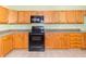 Spacious kitchen featuring wooden cabinets, black appliances, and tile floor at 2761 Winding Creek Ln, Greenfield, IN 46140