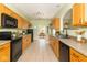 Spacious kitchen featuring wood cabinets and black appliances, providing an eat-in space at 2761 Winding Creek Ln, Greenfield, IN 46140