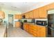 Spacious kitchen with wooden cabinets, black appliances, and a view leading into another room at 2761 Winding Creek Ln, Greenfield, IN 46140