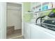 Functional laundry room with washer, dryer, storage shelves, and tiled floor for easy maintenance at 2761 Winding Creek Ln, Greenfield, IN 46140