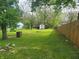 Large backyard with a brick fireplace and wooded perimeter at 2855 Walker Ave, Indianapolis, IN 46203