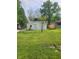 White sided home with green grass and mature trees in the background at 2855 Walker Ave, Indianapolis, IN 46203