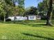 Shot of the home from across the front yard with white siding and trees, garage on left side of frame at 2928 Cicero Rd, Noblesville, IN 46060