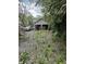 Detached garage with two bays and gravel driveway surrounded by trees at 3031 E 38Th St, Indianapolis, IN 46218