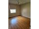 Bedroom boasts hardwood floors, a ceiling fan, and natural light from a large window at 3128 W 12Th St, Anderson, IN 46011
