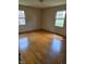 Bright bedroom featuring hardwood floors, two windows offering outdoor views, and ample natural light at 3128 W 12Th St, Anderson, IN 46011
