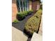 Close-up of manicured landscaping and fresh mulch in front of a brick home with large windows at 3128 W 12Th St, Anderson, IN 46011