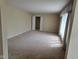 Living room featuring neutral walls and carpet, and large windows at 3128 W 12Th St, Anderson, IN 46011