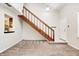 Inviting living room features neutral carpet and a staircase with wooden railing leading to the second floor at 3187 Valley Farms Rd, Indianapolis, IN 46214