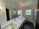 Bright bathroom featuring a double vanity, large mirror, and a shower-tub combination at 3232 St Jude Dr, Indianapolis, IN 46227