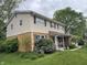 View of a charming two-story home, showcasing a brick and siding exterior with mature trees and landscaping at 3232 St Jude Dr, Indianapolis, IN 46227