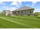 A nicely maintained backyard showing a lush lawn, a brick back patio with fireplace, and the house's exterior at 3424 S Lookout Pass, New Palestine, IN 46163